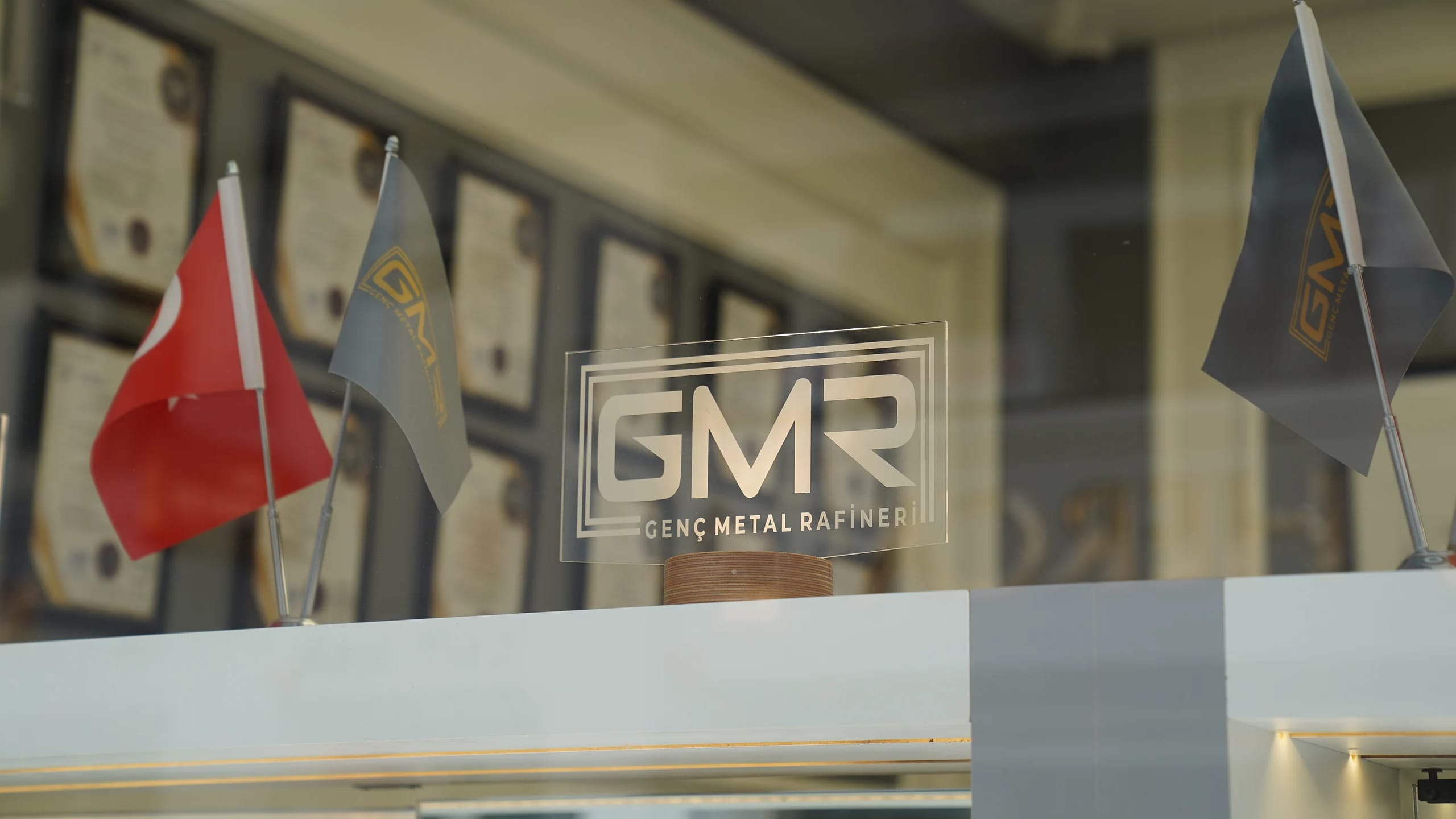 GMR kurumsal binası: cam cephede GMR logosu, Türk bayrağı ve GMR bayrağı
